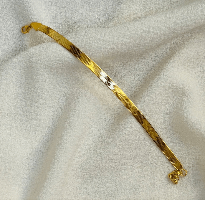 Medusa Bracelet snake chain bracelet in gold vermeil with a sleek design on a soft fabric background.