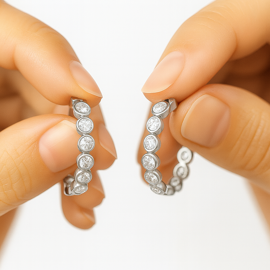 Celeste diamond hoops in hands showcasing their sparkling cubic zircons and sleek design.