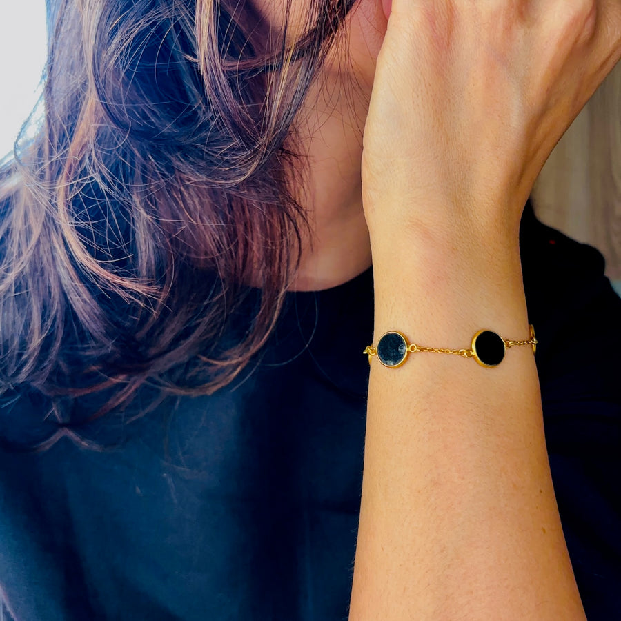 Carbon Bracelet - Black Onyx Beads worn on a wrist with gold accents and elegant design.