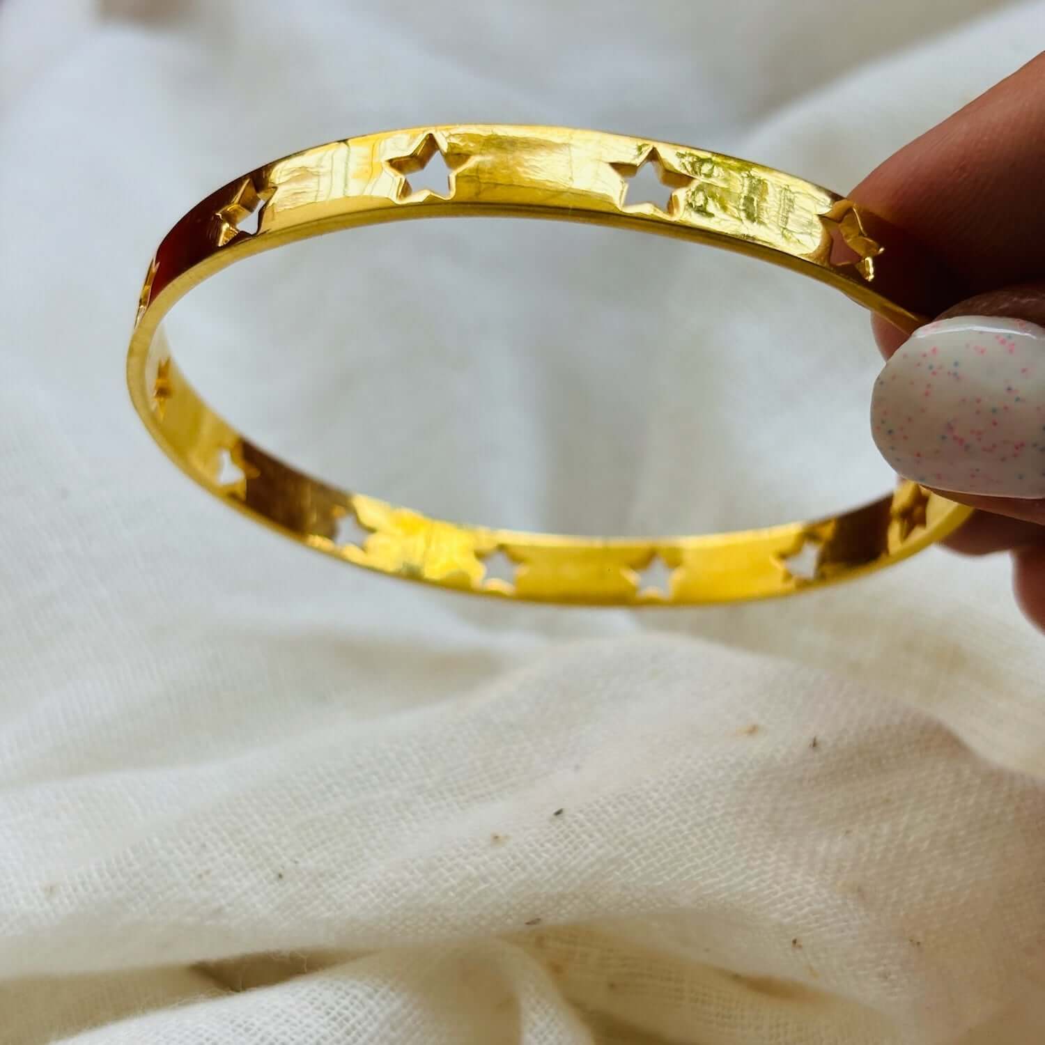 Astra Star Bangle in gold, featuring cut-out star design, symbolizing celestial charm and dreams.