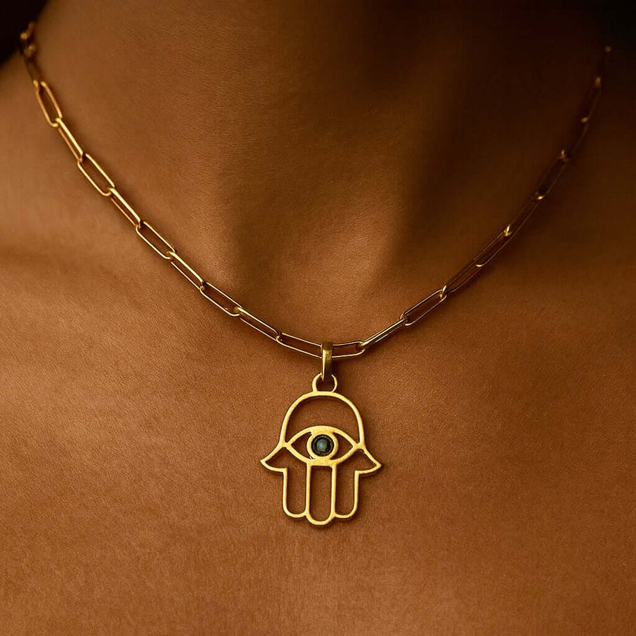 Hamsa Pendant in gold, featuring an eye design, worn on a delicate chain, symbolizing protection and good luck.