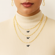 Woman wearing gold necklaces with visible chain lengths on a plain background