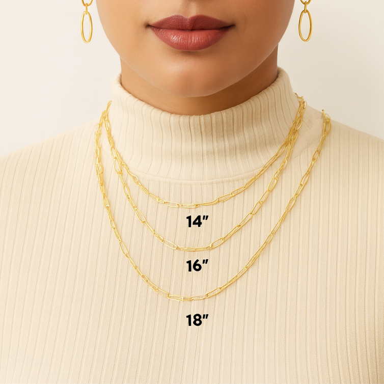 Woman wearing gold necklaces with visible chain lengths on a plain background