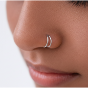 The Reya Double Band Nose Ring worn close to the nose, showcasing two fine parallel bands in 92.5 sterling silver.