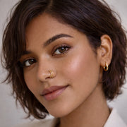 A close-up of a woman wearing The Reya Double Band Nose Ring, showcasing its elegant design in sterling silver.