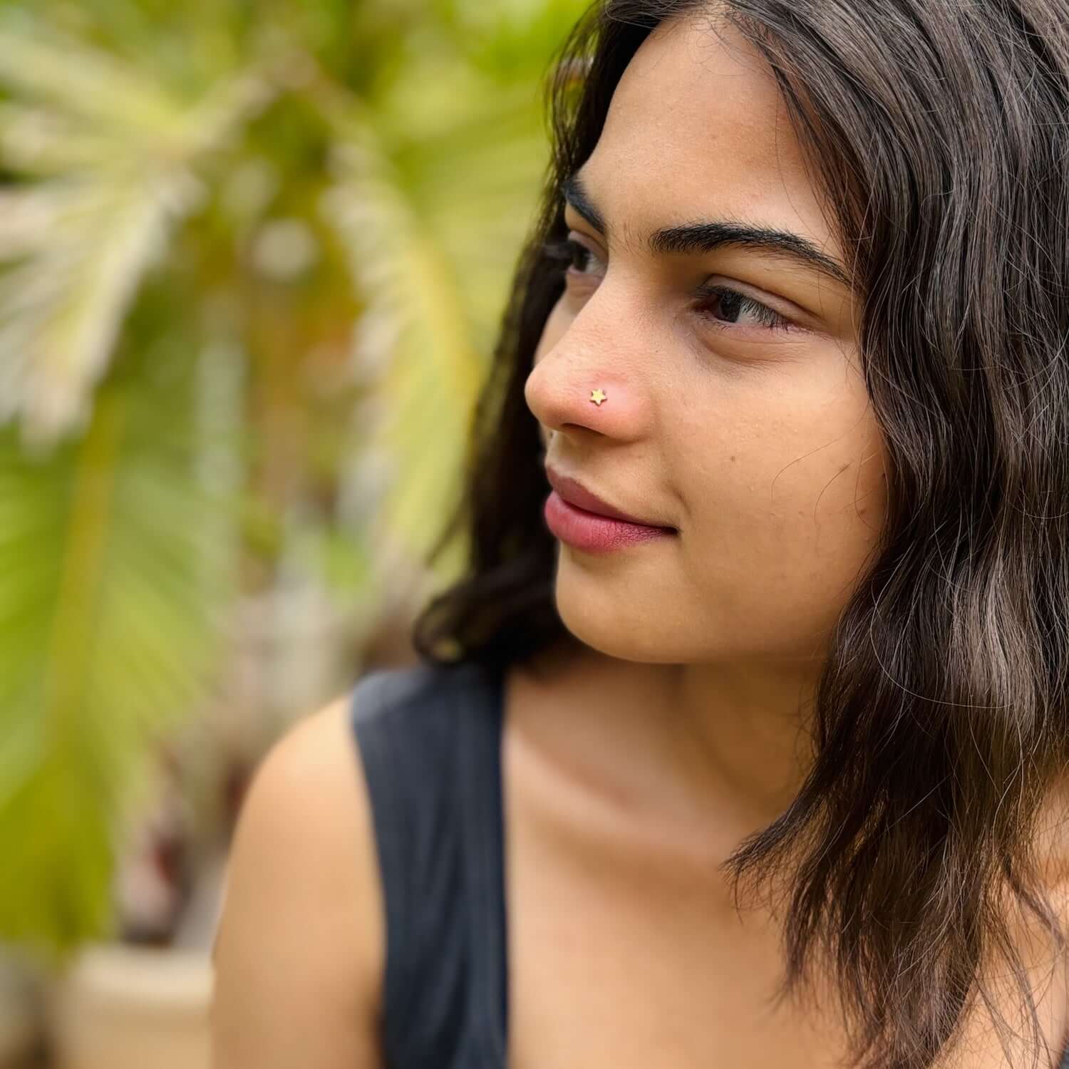Close-up of a woman wearing the Sitara Nose Pin - Star Nose Pin, showcasing its subtle sparkle against her natural look.
