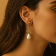 Gold earring with pearl drop worn by a person