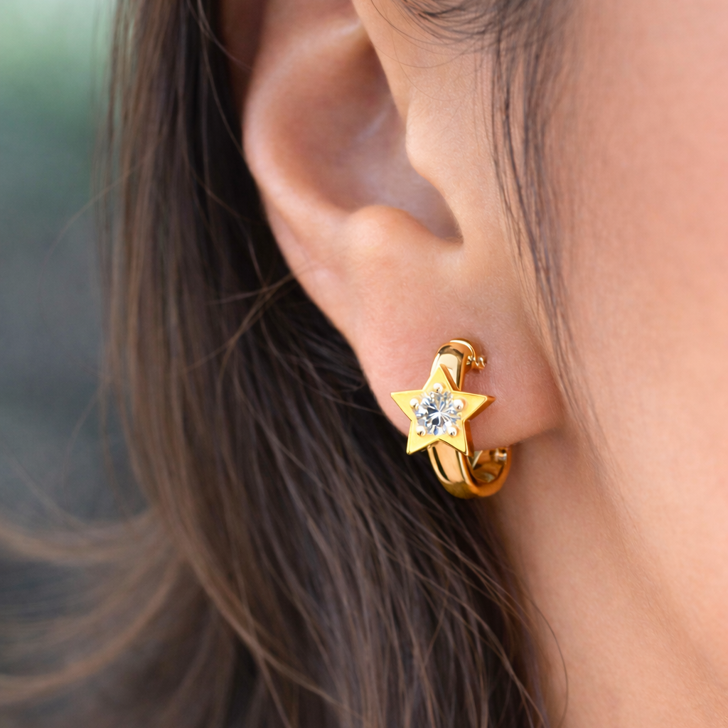 Gold star-shaped earring with a clear gemstone worn by a person.
