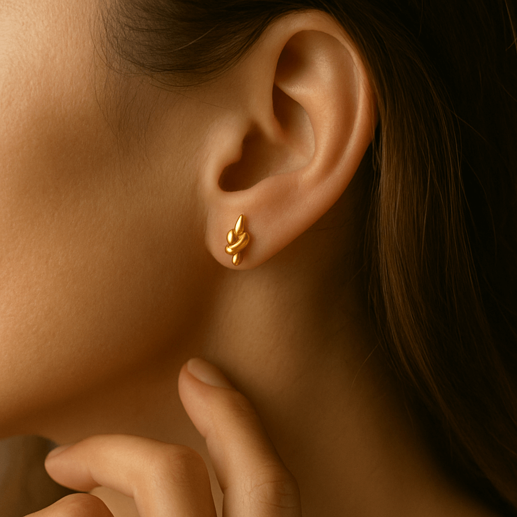 Close-up of a person wearing a gold earring with a blurred background