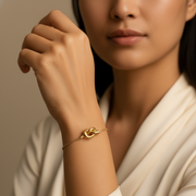 The Knot Bracelet elegantly worn on a woman's wrist, showcasing its simple yet sophisticated design.