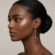 Silver heart-shaped earrings worn by a model