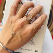 Hand wearing a silver ring on a book