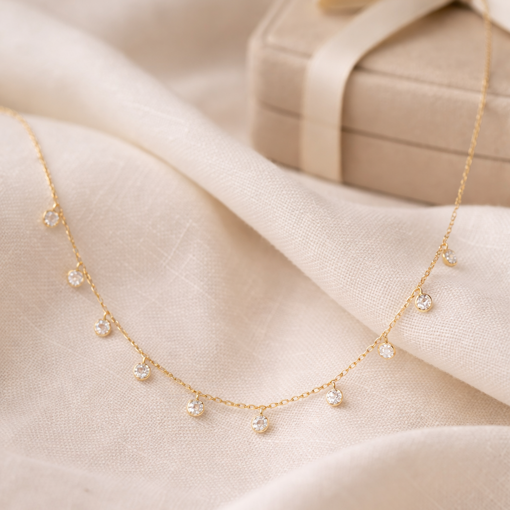 Gold necklace with small pearls on a soft beige fabric background
