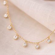 Gold necklace with small diamonds on a beige fabric background