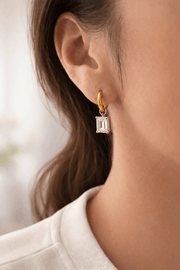 Everyday diamond earrings showcased on a model, featuring a cubic zircon diamond drop suspended from a gold hoop.