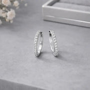 Everyday Diamond Huggies showcasing a pair of sparkly hoops adorned with tiny cubic zirconia stones.