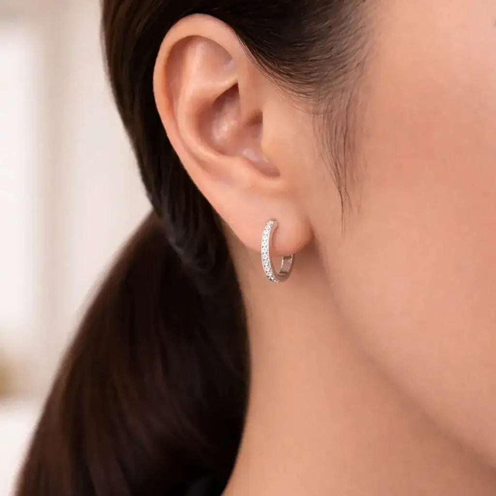 Close-up of a woman wearing everyday diamond huggies, showcasing their sparkling cubic zirconia stones.