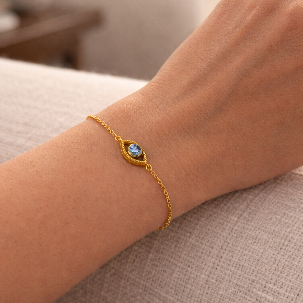 Netra - The contemporary evil eye bracelet worn on a wrist, showcasing its 18k gold vermeil and blue gemstone.
