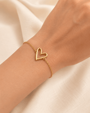 Mehr Heart Bracelet featuring a delicate open heart charm on a woman's wrist.