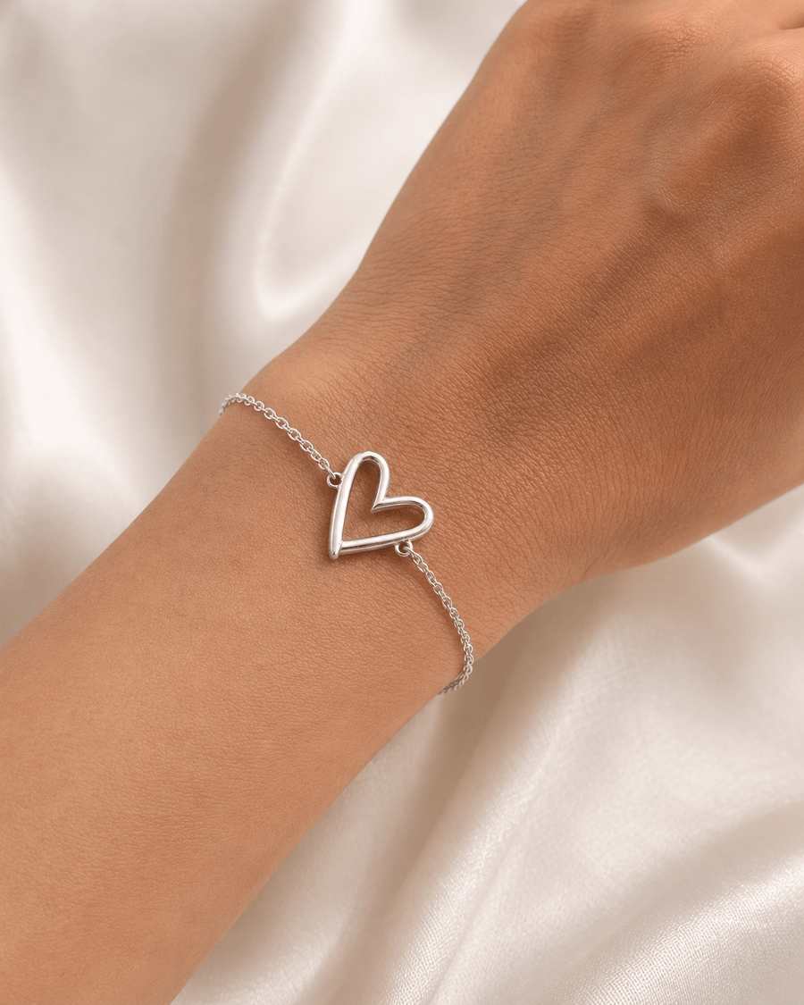 A close-up of the Mehr Heart Bracelet featuring a delicate open heart charm on a wrist.