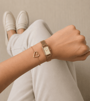 Hand wearing a Mehr Heart Bracelet alongside a stylish wristwatch, showcasing a modern and elegant look.