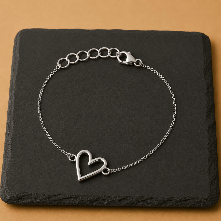 Mehr Heart Bracelet featuring a delicate open heart charm on a silver chain, set against a sleek black background.