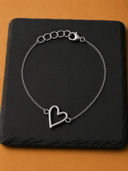 Elegant Mehr Heart Bracelet featuring an open heart charm on a black slate background.