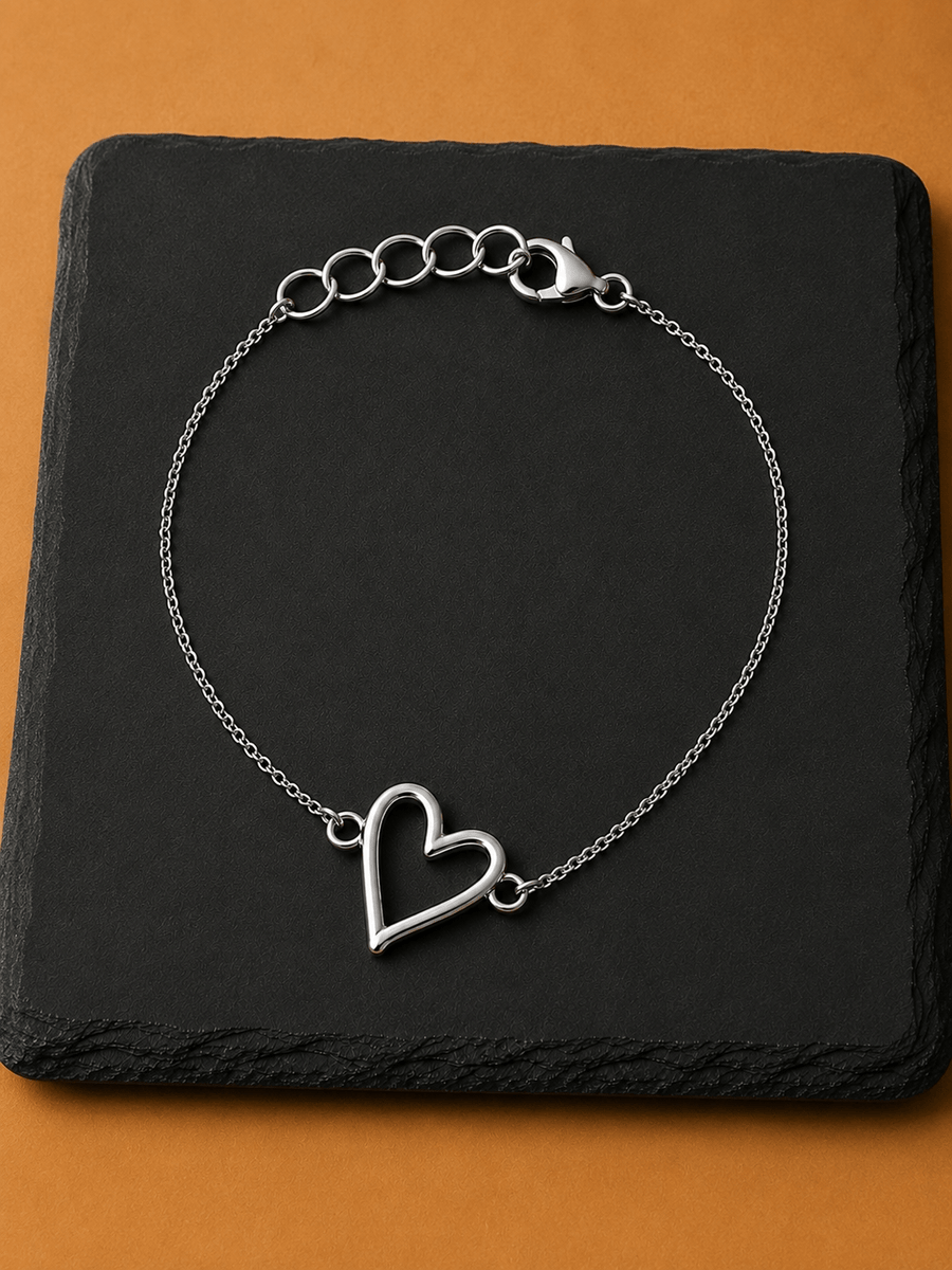 Elegant Mehr Heart Bracelet featuring an open heart charm on a black slate background.