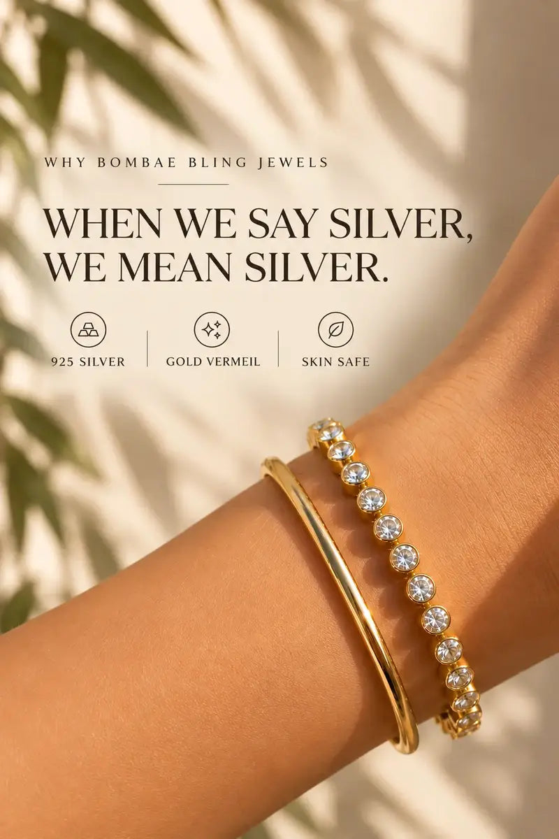 A close-up of a person's wrist wearing two bracelets: a plain polished gold bangle and a silver-toned tennis bracelet with clear stones. The image includes marketing text reading 'WHEN WE SAY SILVER, WE MEAN SILVER.